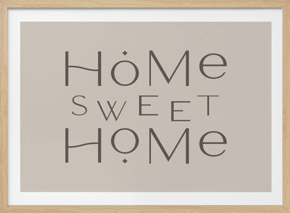 A minimalist wall art piece with the words 'Home Sweet Home' in a dark gray, stylized sans-serif font against a light beige background, all housed within a simple silver frame. Decor
