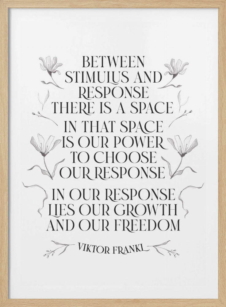 A framed black and white art print featuring an inspirational quote by Viktor Frankl. The quote reads, 'Between stimulus and response there is a space. In that space is our power to choose our response. In our response lies our growth and our freedom.' The text is rendered in a classic serif font and is flanked by delicate, gray floral illustrations. Wall Art