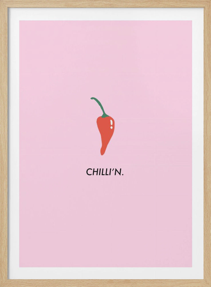 A minimalist art print in a black frame with a light pink background. In the center is a simple illustration of a red chili pepper with a green stem. Below it, the text 'CHILLI'N.' is printed in a black sans-serif font, creating a pun. Poster