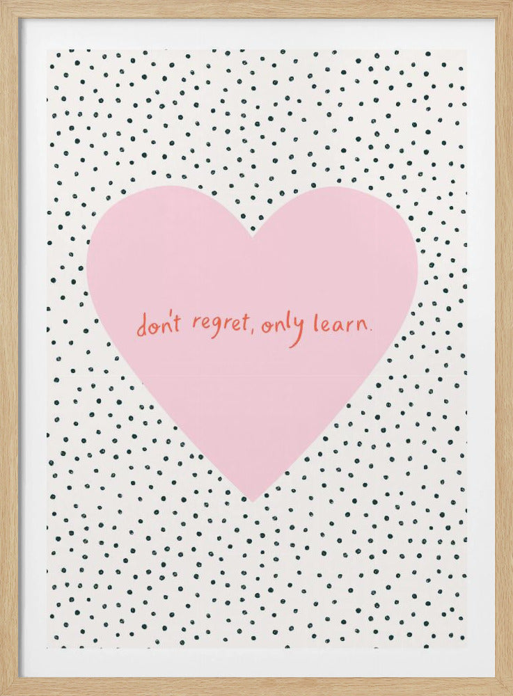 A framed poster with a white background covered in black polka dots. A large pink heart is in the center with the motivational quote 'don't regret, only learn.' written in red script. Artwork