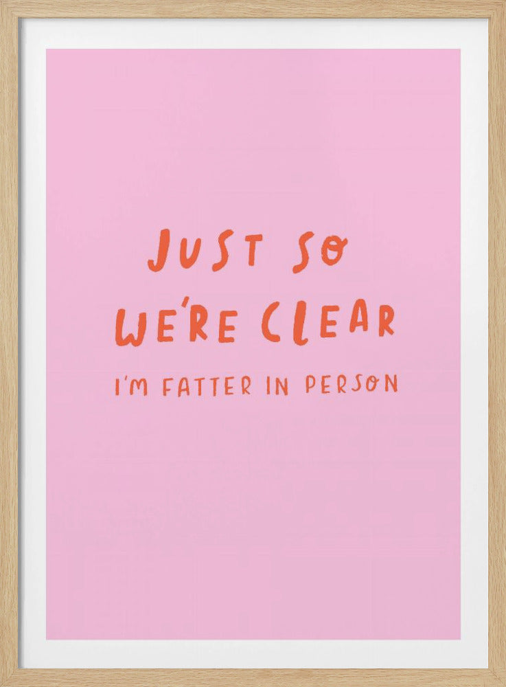 A framed art print with a pink background and orange text. The text, in a casual handwritten font, reads 'JUST SO WE'RE CLEAR' in large letters, followed by 'I'M FATTER IN PERSON' in smaller letters below. Artwork