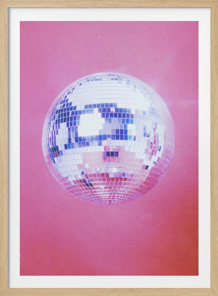 A retro-style photograph of a sparkling silver disco ball centered against a solid, grainy pink background, all within a thin black frame. Print