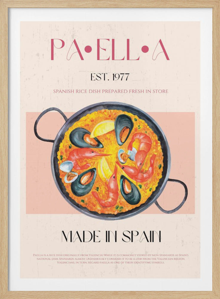A vintage-style food poster advertising paella. It features a large watercolor illustration of a paella pan filled with yellow rice, shrimp, and mussels. The text reads 'PAELLA', 'EST. 1977', and 'MADE IN SPAIN' in stylized fonts on a textured pink background with a black frame. Print