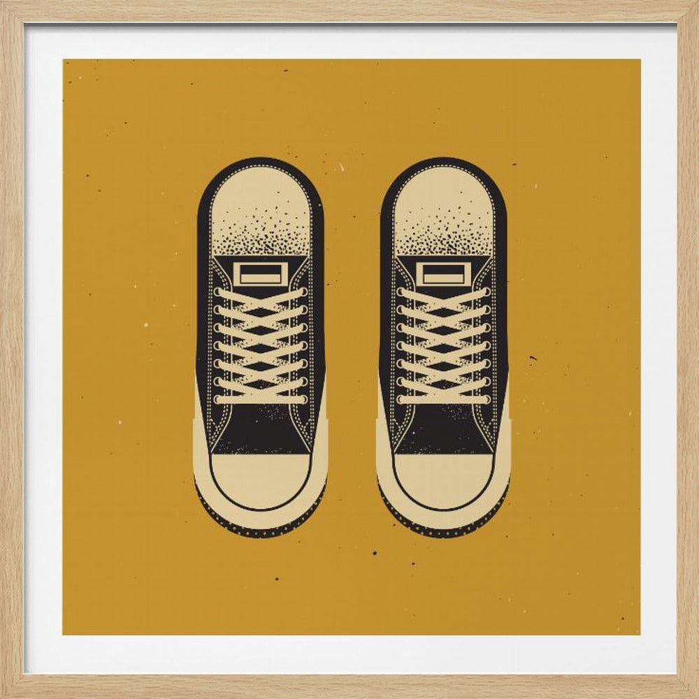 A vintage-style graphic art print of a pair of black and cream high-top sneakers, seen from a top-down perspective, set against a solid mustard yellow background with a distressed texture, all enclosed in a light wood frame. Wall Art