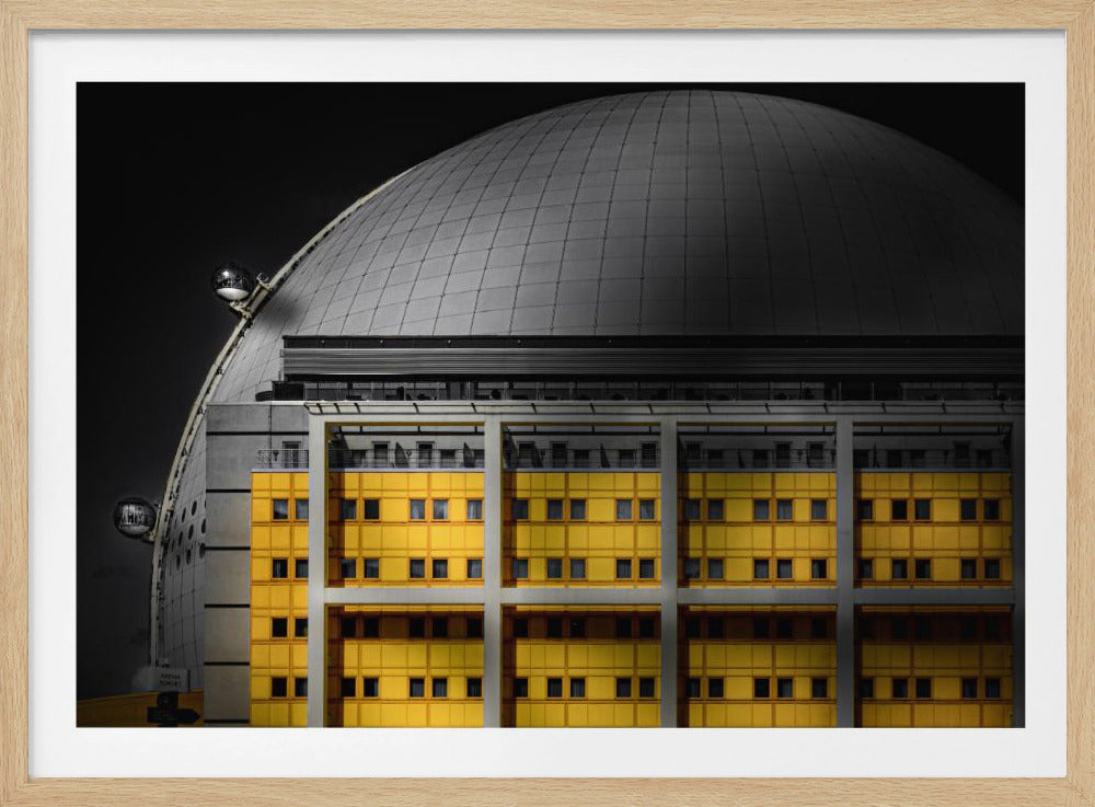 A framed architectural photograph with selective color, featuring a bright yellow building in the foreground against a monochrome background of a large grey dome structure under a black sky. Wall Art