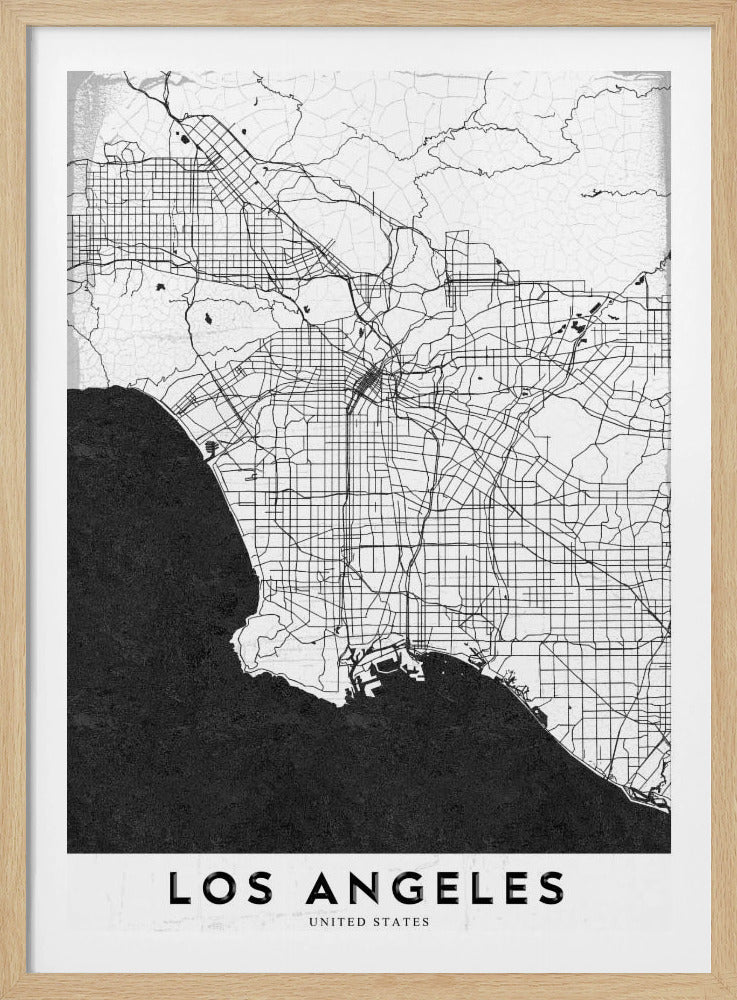 A minimalist black and white framed poster of a street map of Los Angeles. The land is white with an intricate grid of black lines representing roads and highways, while the Pacific Ocean is a solid, textured black. A white band at the bottom contains the city's name, 'LOS ANGELES', in a bold, black sans-serif font. Decor