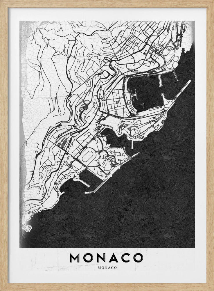 A modern black and white map of Monaco, presented as a framed poster. The map details the city's streets and coastline in black lines on a white background, while the sea is depicted in a solid, textured black. The title 'MONACO' is at the bottom in a bold, white band. Poster