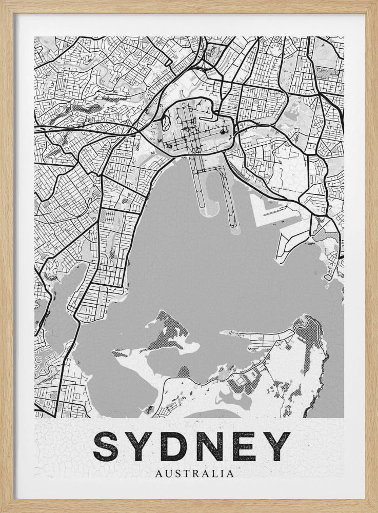 A modern, black and white framed art print of a stylized map of Sydney, Australia. The map features bold black lines for the street grid and major roads, with light grey for the landmass and a darker grey for the water of the harbor. The word 'SYDNEY' is printed in large, black, sans-serif font at the bottom of the poster. Poster