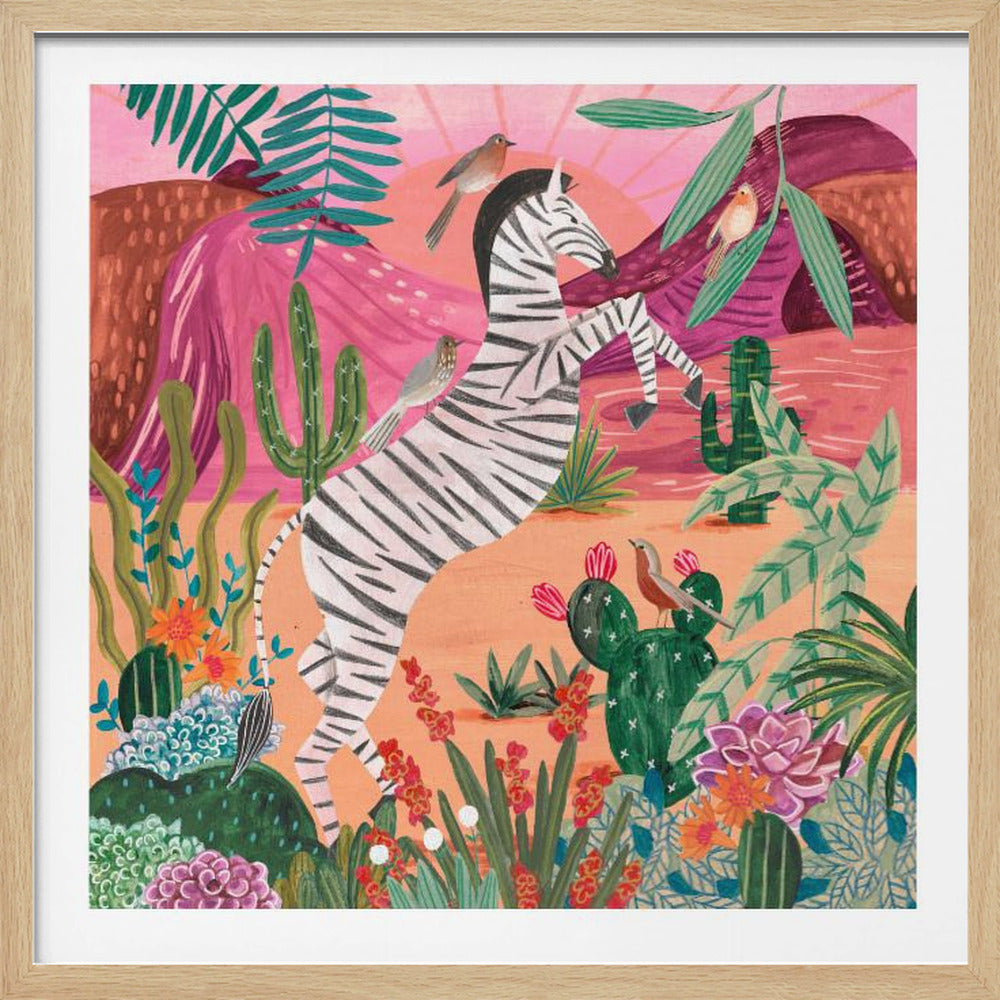 A stylized painting of a zebra rearing on its hind legs in a vibrant desert landscape. It's surrounded by colorful cacti, tropical plants, and small birds against a backdrop of pink mountains and a setting sun, all enclosed in a light wood frame. Artwork