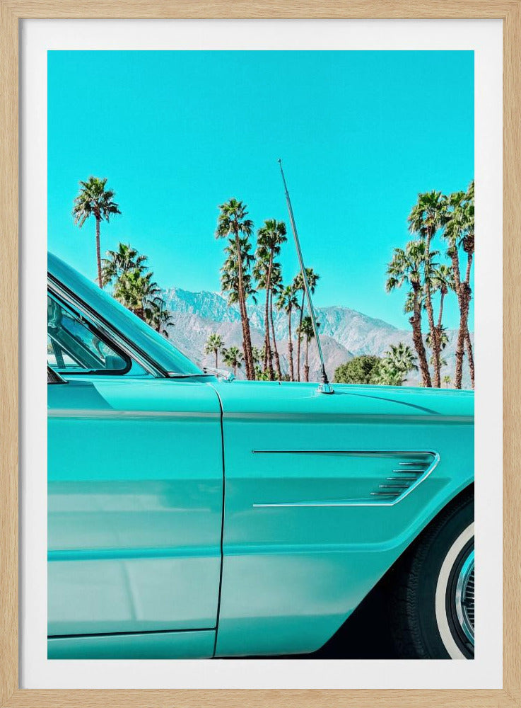 A vibrant, stylized photograph of a vintage turquoise car parked under a clear blue sky, with a row of tall palm trees and distant mountains creating a classic, sunny California scene. Wall Art