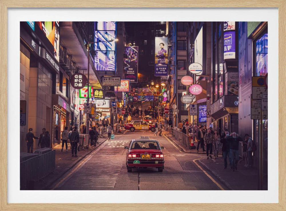 A vibrant nighttime scene looking up a crowded, hilly street in Hong Kong, with a red taxi in the foreground. The street is flanked by tall buildings adorned with a multitude of glowing neon signs in both English and Chinese, illuminating the many pedestrians on the sidewalks. Poster