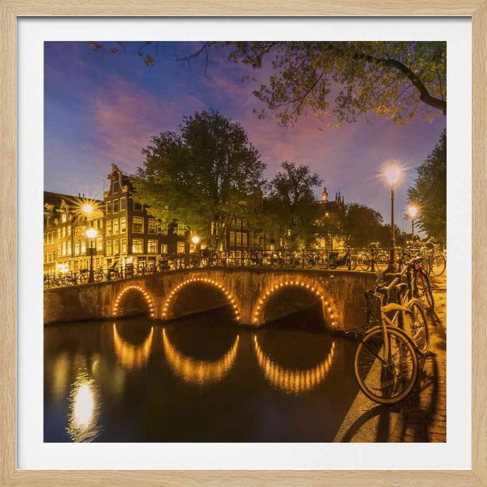 An idyllic nightscape view of Keizersgracht canal in Amsterdam, featuring illuminated buildings reflecting on the water under a dark sky. Wall Art