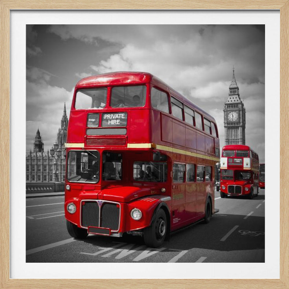 A framed, selective color photograph of a bright red, vintage double-decker bus on a bridge in London. The background, including the Big Ben clock tower, is in black and white, making the red bus stand out. Artwork