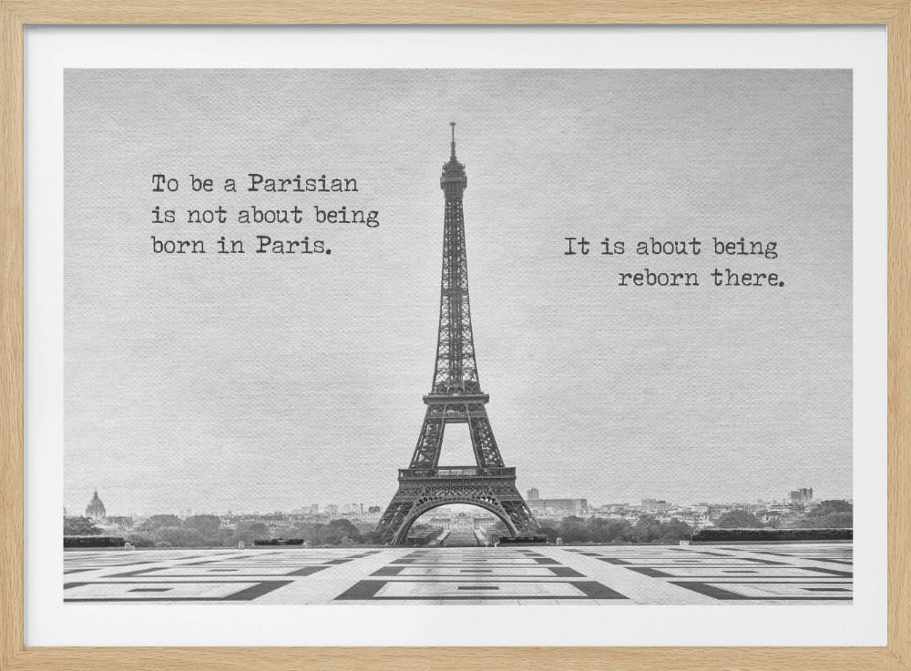 A framed, black and white photograph of the Eiffel Tower in Paris. The image includes the text 'To be a Parisian is not about being born in Paris. It is about being reborn there.' split on either side of the iconic landmark. Poster