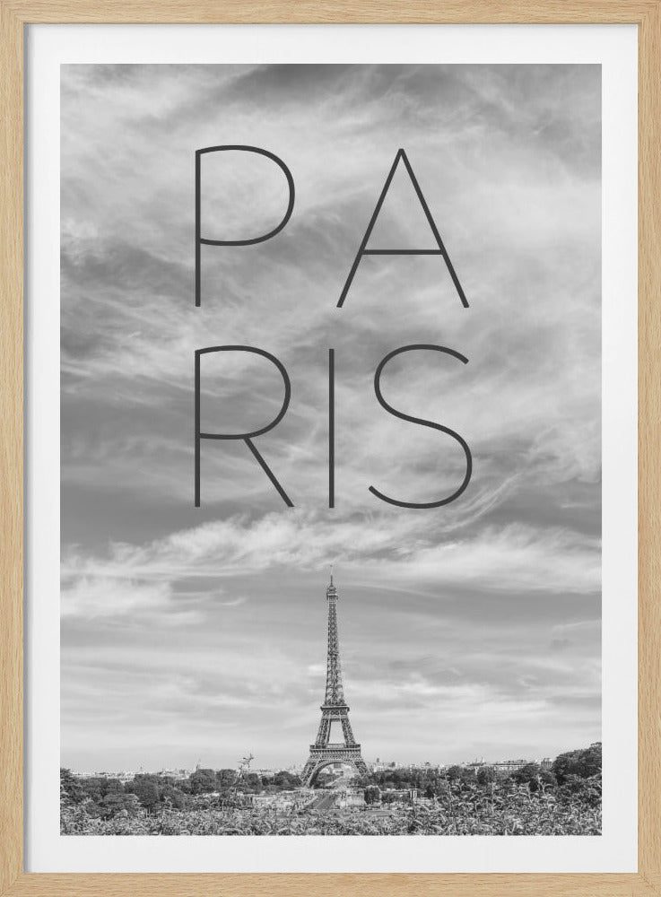 A black and white vertical poster featuring the word 'PARIS' in a large, thin, modern font. The text is superimposed over a dramatic cloudy sky, with the Eiffel Tower and the city skyline visible at the bottom. The image is enclosed in a thin black frame. Poster