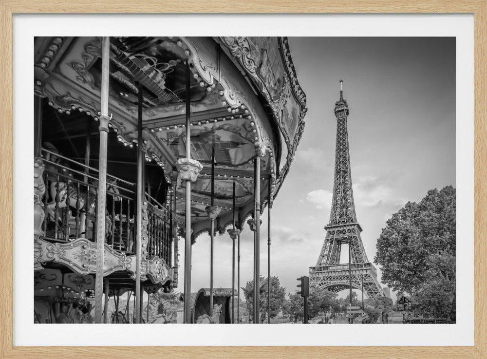 A classic black and white photograph capturing a vintage carousel in the foreground with the iconic Eiffel Tower standing majestically in the background in Paris, France. The image is framed with a silver border. Artwork