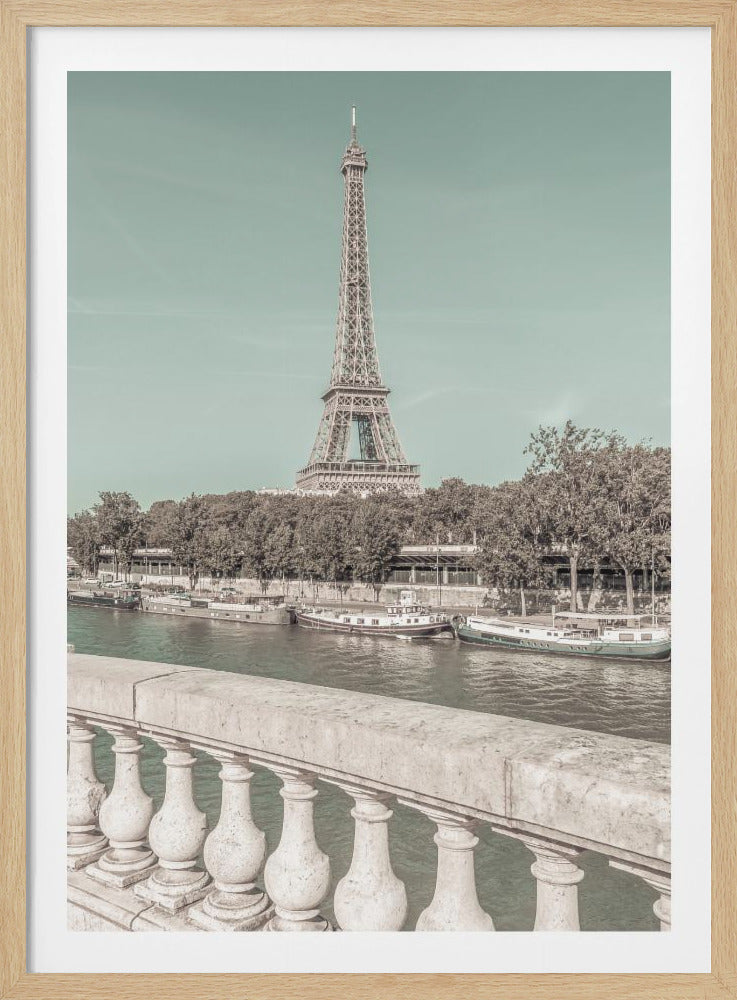 A vintage-style photograph of the Eiffel Tower in Paris, seen from a bridge overlooking the River Seine. The sky is a soft teal color, while the tower, trees, and river are rendered in muted, desaturated tones, giving the image a nostalgic feel. Wall Art