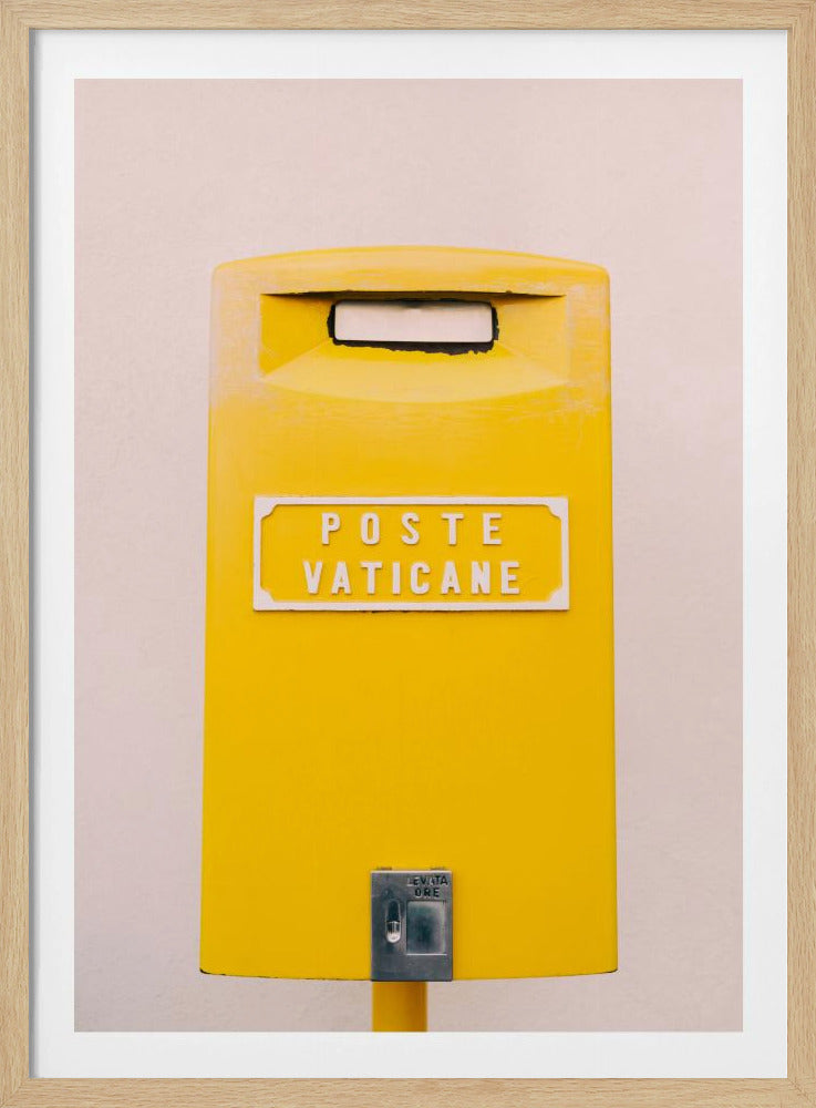 A close-up, front-view photograph of a vibrant yellow Vatican City mailbox against a plain beige wall, enclosed in a thin black frame. The words 'POSTE VATICANE' are printed in white on the front. Artwork