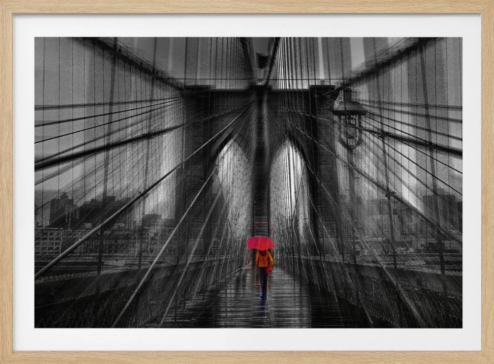A motion-blurred, black and white photo of the Brooklyn Bridge with a person holding a bright red umbrella walking down the center. The selective color makes the red umbrella the focal point against the dramatic, almost abstract lines of the bridge's cables and arches on a wet, reflective walkway. The image is presented in a silver frame. Wall Art