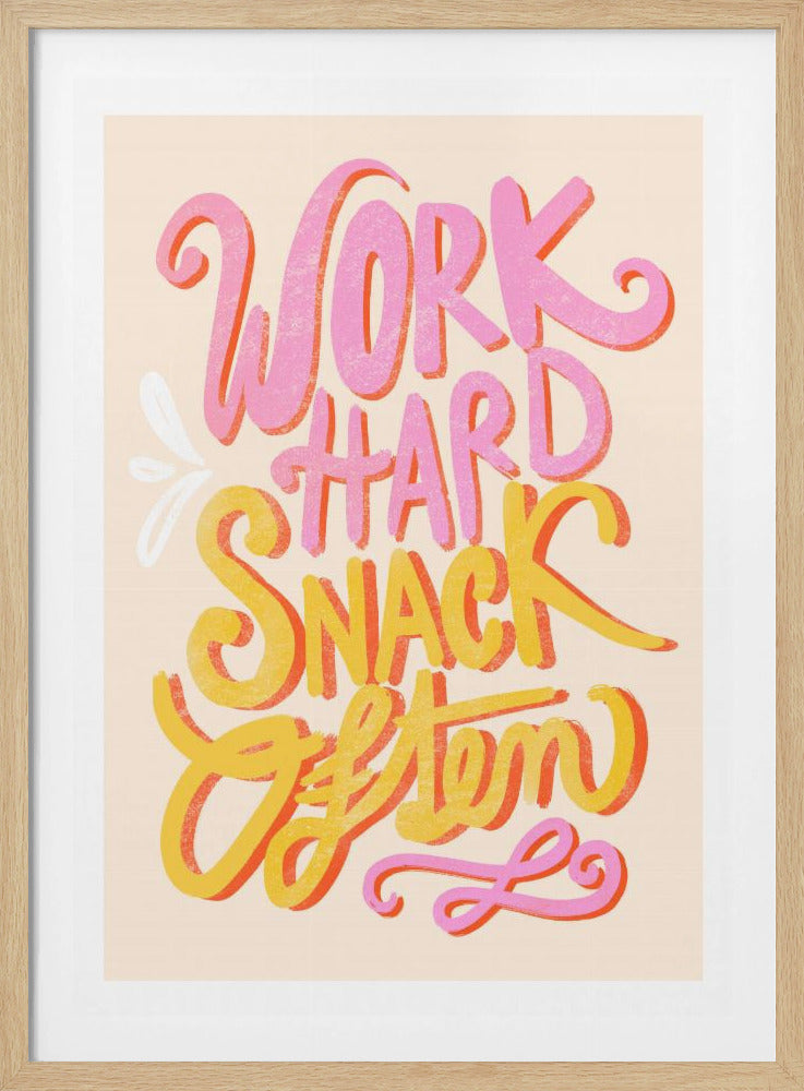 A colorful typographic art print with the phrase 'Work Hard Snack Often'. The words 'Work Hard' are in pink and 'Snack Often' are in yellow, both with an orange shadow effect. The hand-lettered text is on a light cream background and framed in black. Print