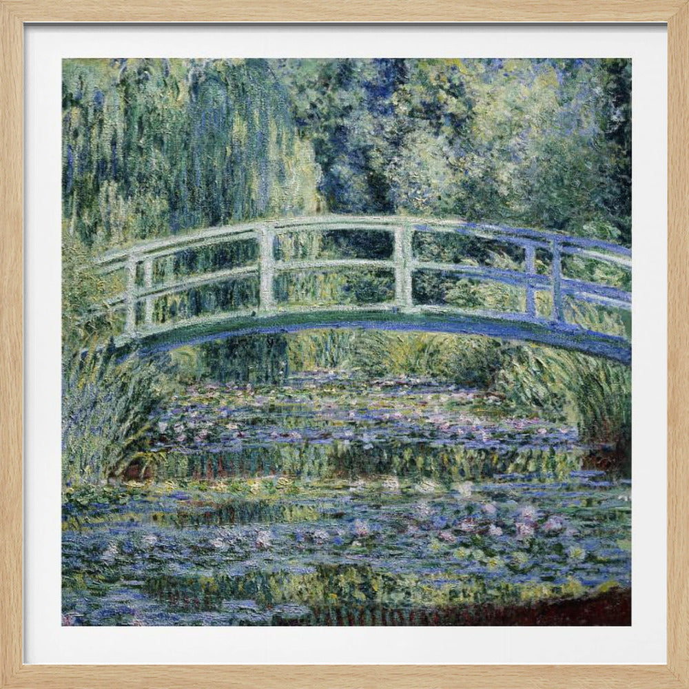 An Impressionist painting by Claude Monet, 'The Water Lily Pond', in a light wood frame. A pale green Japanese footbridge arches over a tranquil pond filled with pink and white water lilies, reflecting the lush green and blue foliage of weeping willows that surround it. Poster