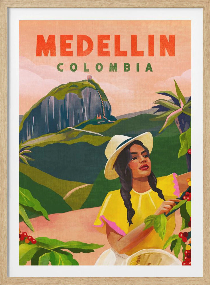 A vintage-style travel poster for Medellin, Colombia. In the foreground, a woman with braided hair wearing a yellow shirt and a white hat harvests red coffee beans. The background features the lush green hills of Colombia and the iconic El Peñón de Guatapé rock formation under a peach-colored sky. The text 'MEDELLIN COLOMBIA' is displayed at the top in large orange and green letters. Decor