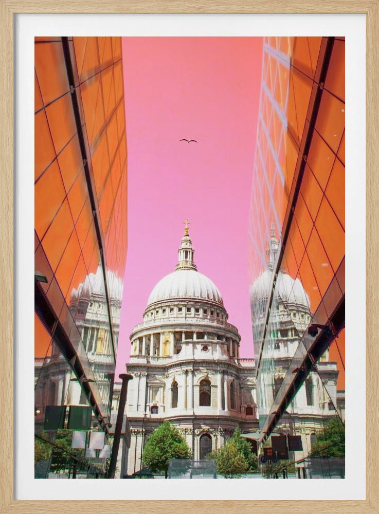 A low-angle, surrealist photograph of a classic white dome cathedral, framed perfectly between two modern orange glass buildings. The cathedral's reflection is visible on the buildings' surfaces against a vibrant, solid pink sky with a lone bird in flight. Poster