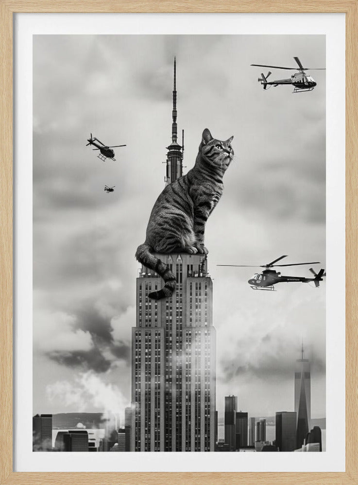 A surreal black and white image depicting a giant tabby cat sitting on top of the Empire State Building, similar to King Kong. Helicopters fly around the colossal cat against a cloudy New York City skyline. Decor