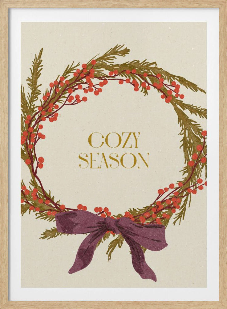 A vintage-style illustration of a festive wreath made of green boughs and red berries, tied with a large purple bow at the bottom. The text 'COZY SEASON' is written in gold inside the wreath on a cream-colored background, all enclosed in a thin black frame. Wall Art