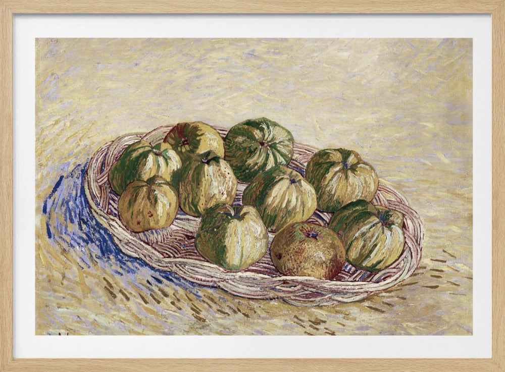 A post-impressionist still life painting by Vincent van Gogh showing a woven basket full of green and yellow apples. The background is a textured pale yellow, and the artist's signature is visible in the bottom left. The artwork is presented in a silver frame. Poster