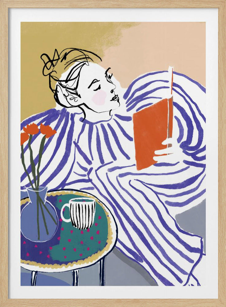 A stylized, framed illustration of a person with dark hair in a messy bun, wearing a blue and white striped top, reclining comfortably while engrossed in an orange book. Beside them is a small table with a blue vase holding three orange flowers and a black and white striped mug. The background is a soft beige color. Print