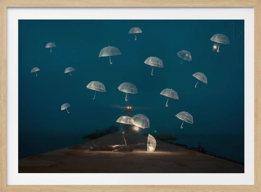 A surreal night scene with a person lying on a pier next to a glowing, transparent umbrella, while numerous other glowing umbrellas float like jellyfish in the dark blue sky above the sea, with a distant lighthouse in the background. Poster