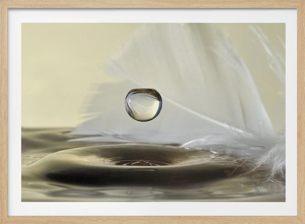 A high-speed macro photograph captures a perfectly spherical water droplet suspended in mid-air above a ripple on the water's surface. A soft white feather lies in the background, creating a serene and delicate composition with a neutral color palette, all enclosed in a brushed silver frame. Wall Art