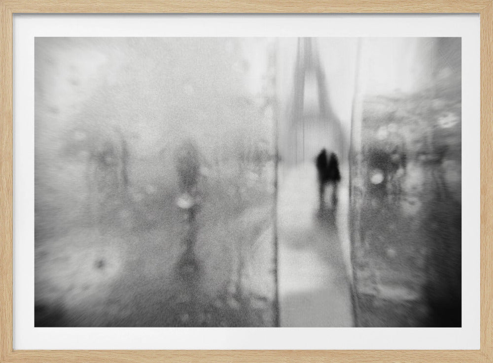 A framed, moody black and white photograph with a heavy blur effect, depicting a couple's silhouette walking towards the distant, hazy Eiffel Tower on what appears to be a rainy day in Paris. Artwork