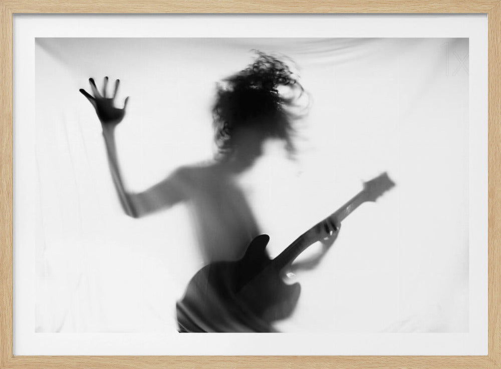 A striking black and white photo of a musician's silhouette seen through a translucent sheet. The figure has wild, flying hair and holds an electric guitar, while one hand is pressed against the sheet, creating a dramatic, high-energy effect. The image is enclosed in a simple silver frame. Print