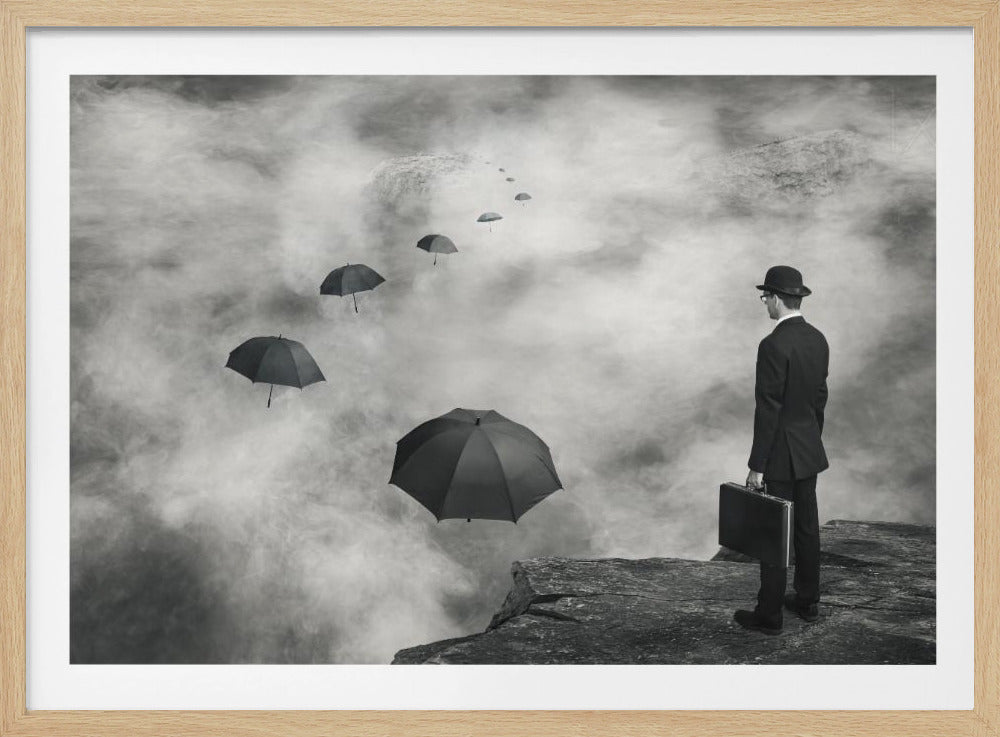A surreal black and white photograph of a man in a suit and bowler hat holding a briefcase, standing on a cliff edge. He gazes into a foggy expanse where a path of floating black umbrellas leads into the misty distance. Decor