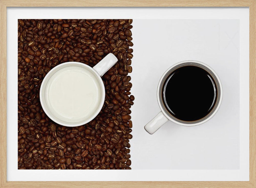 A top-down, split-screen photograph showing a contrast between coffee and milk. On the left, a white mug of milk sits on a bed of roasted coffee beans. On the right, a white mug of black coffee rests on a clean white background, creating a stark visual divide. Artwork