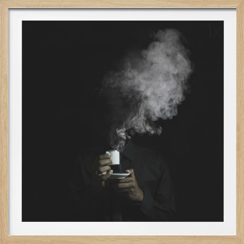 A surreal black and white photograph of a person in a dark shirt holding a white espresso cup, with their head completely obscured by a large plume of rising smoke, all set against a pitch-black background and framed in light wood. Print