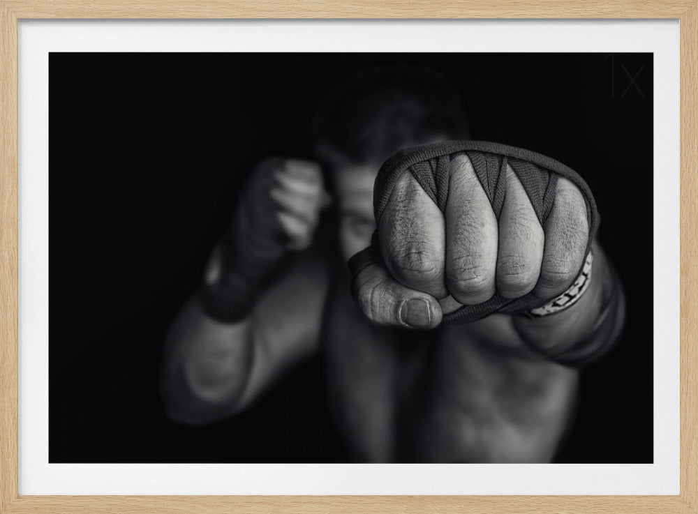 A dramatic black and white close-up photograph of a boxer's wrapped fist punching towards the camera. The fighter's body and other fist are blurred in the background, creating a powerful and intense mood. Print
