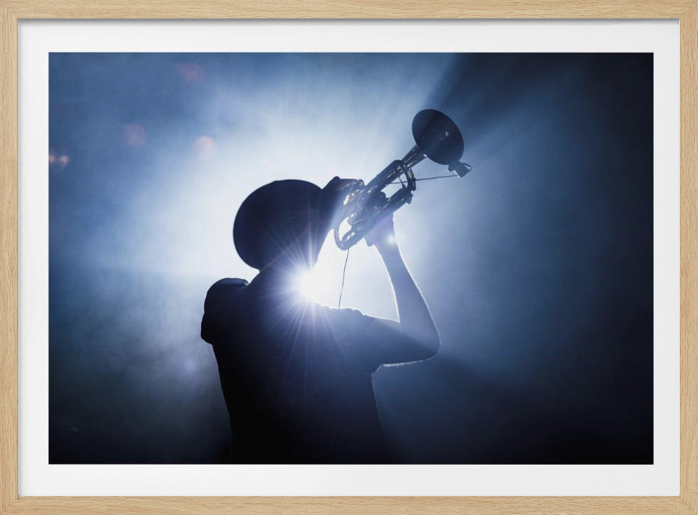 A musician in silhouette plays the trumpet against a bright white and blue spotlight on a hazy stage. The light creates a starburst effect, highlighting the form of the performer and their instrument. Poster