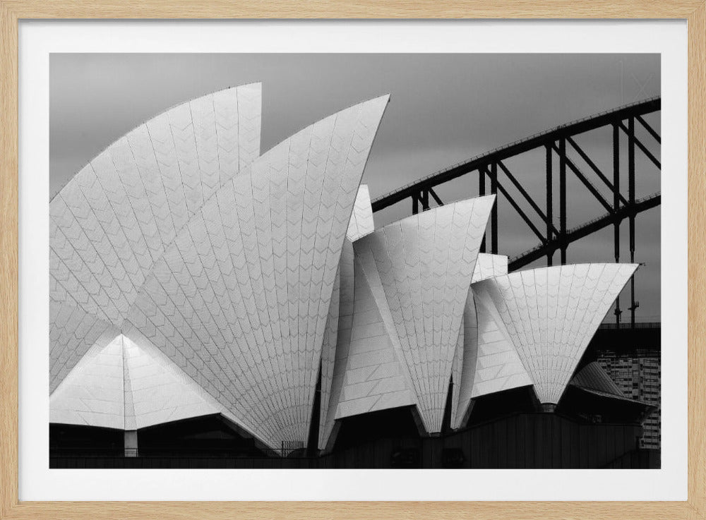 A framed black and white photograph focusing on the detailed, textured sails of the Sydney Opera House, with the Sydney Harbour Bridge visible in the background under a cloudy sky. Artwork