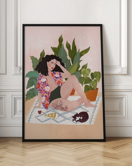 An illustration of a woman with dark curly hair relaxing on a patterned blanket indoors. She is wearing a green swimsuit and a pink floral shirt, with a prominent snake tattoo on her thigh. Next to her is a slice of pizza, a glass of red wine, and a sleeping black and white cat, all set against a backdrop of large green houseplants and a pink wall. Artwork