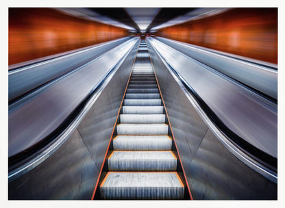 A symmetrical, low-angle photograph looking up a very long escalator, creating a strong sense of perspective towards a vanishing point. The orange walls are motion-blurred, suggesting speed, while the metallic steps in the center remain clear. Decor