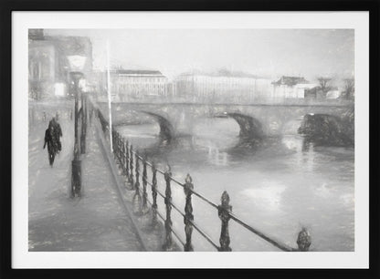 A framed, black and white impressionistic artwork of a city scene on a foggy or rainy day. In the foreground, a dark metal railing runs along a riverside walkway where a person in a dark coat is walking. An arched stone bridge crosses the river in the midground, with hazy buildings visible in the background, creating a moody and atmospheric scene. Wall Art