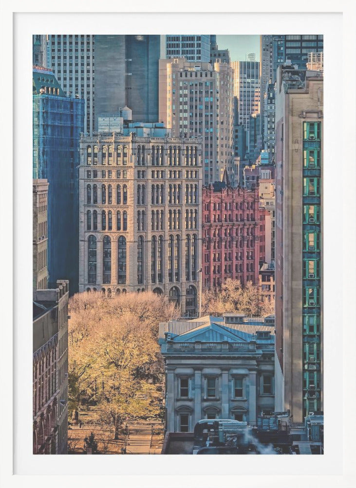 A high-angle view of a dense city skyline featuring a mix of old and new architectural styles. Golden light illuminates the autumn foliage of a park and the facades of several buildings, creating a warm contrast with the cool blue tones of the skyscrapers in the background. Decor