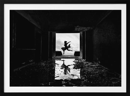A dramatic black and white photo of a silhouetted dancer leaping in a bright doorway, viewed from inside a dark, derelict building. The dancer's reflection is captured in a puddle on the rubble-strewn floor. Poster