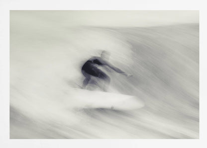 An artistic black and white photograph using motion blur to capture a surfer in a dynamic, fluid pose on a wave. The slow shutter speed creates a sense of speed and abstract movement, with the surfer's dark wetsuit contrasting against the white, streaked water. The image is presented in a silver frame. Decor