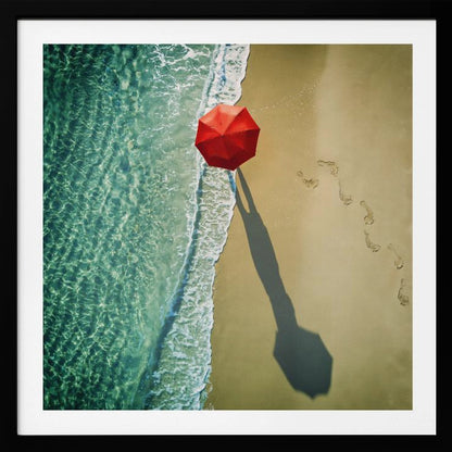 An aerial photograph of a serene beach scene, featuring a vibrant red umbrella on the golden sand next to the clear turquoise ocean. Gentle white waves lap the shore, and a long shadow from the umbrella stretches across the sand, where a trail of footprints leads away. Poster