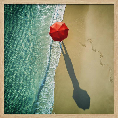 An aerial photograph of a serene beach scene, featuring a vibrant red umbrella on the golden sand next to the clear turquoise ocean. Gentle white waves lap the shore, and a long shadow from the umbrella stretches across the sand, where a trail of footprints leads away. Poster