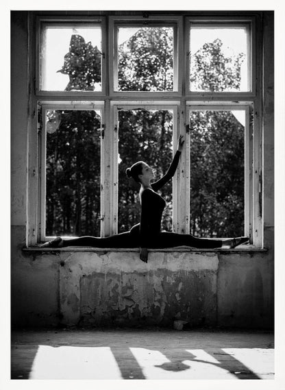 A black and white photograph of a graceful female dancer holding a perfect split on a large, dilapidated windowsill. She is silhouetted against the bright light from the broken window panes, with her arm elegantly raised. The setting is an abandoned room with peeling paint, creating a stark contrast between the dancer's elegance and the decaying environment. Wall Art